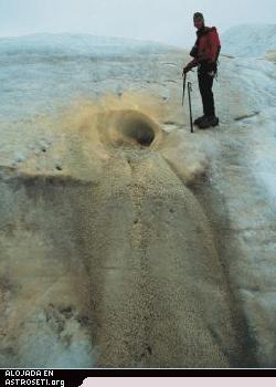 <a href=" http://www.planetary.org/image/borup_ground_sulfur_spring_discharge_site.jpg">Click to enlarge </a>>
<b>Un manantial de azufre descarga de un glaciar en el Paso del Fiordo Borup</b>
En esta foto de la temporada de campo del 2000, se ha formado un terraplén de “colada” de azufre y yeso de 4 metros de alto bajo un canal horizontal de expulsión. La boca del canal había desaparecido cuando el lugar fue revisitado en 2001. Crédito: Stephen E. Grasby