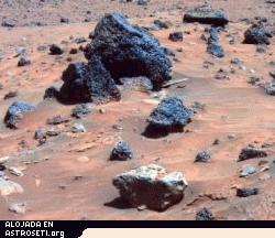 Pinche <a href="http://www.planetary.org/image/Spirit_AllanHills_meteorite_false-color-A865R1_063006_br2.jpg">aqu�</a> para ampliar la imagen
<strong>Allan Hills-en Marte</strong>
La roca de tono gris claro en el centro del primer plano de esta imagen es sospechoso de ser un meteorito de hierro. Spirit tom� esta imagen con la PanCam durante el Sol 809 (12 de Abril, 2006), no mucho despu�s de llegar a su refugio de invierno, Low Ridge. Esta roca, llamada Allan Hills, y una roca similar llamada Zhong Shan, justo fuera del campo de visi�n hacia la izquierda, tiene una textura m�s suave y un tono m�s claro que otras rocas en la zona. La textura y el brillo de este par recordaron a algunos de los miembros del equipo cient�fico del rover a una roca llamada Heat Shield Rock, observada por Opportunity en la zona de Meridiani de Marte hace m�s de un a�o. El examen de la composici�n de esa roca confirm� que se trataba de un meteorito de hierro. Esta imagen es una versi�n a color falso para enfatizar las diferencias entre los materiales de roca y de suelo.
Cr�dito: NASA/JPL-Caltech/Cornell
