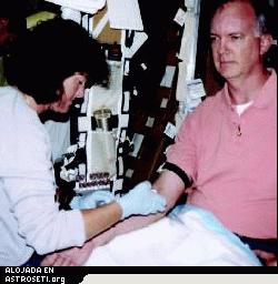 <i>Con el fin de prepararse para los experimentos en ciencia de la vida durante la misi�n STS-107, la astronauta Dra. Laurel Clark extrae sangre del voluntario y astronauta sustituto John Charles, cient�fico de misi�n para los experimentos OBPR en el vuelo del Columbia en julio.</i>