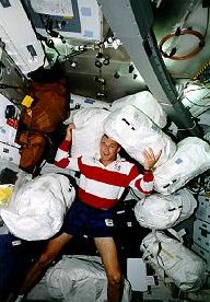 El piloto del transbordador Terry Wilcutt con 7 dep�sitos de contingencia destinados a la estaci�n espacial Mir